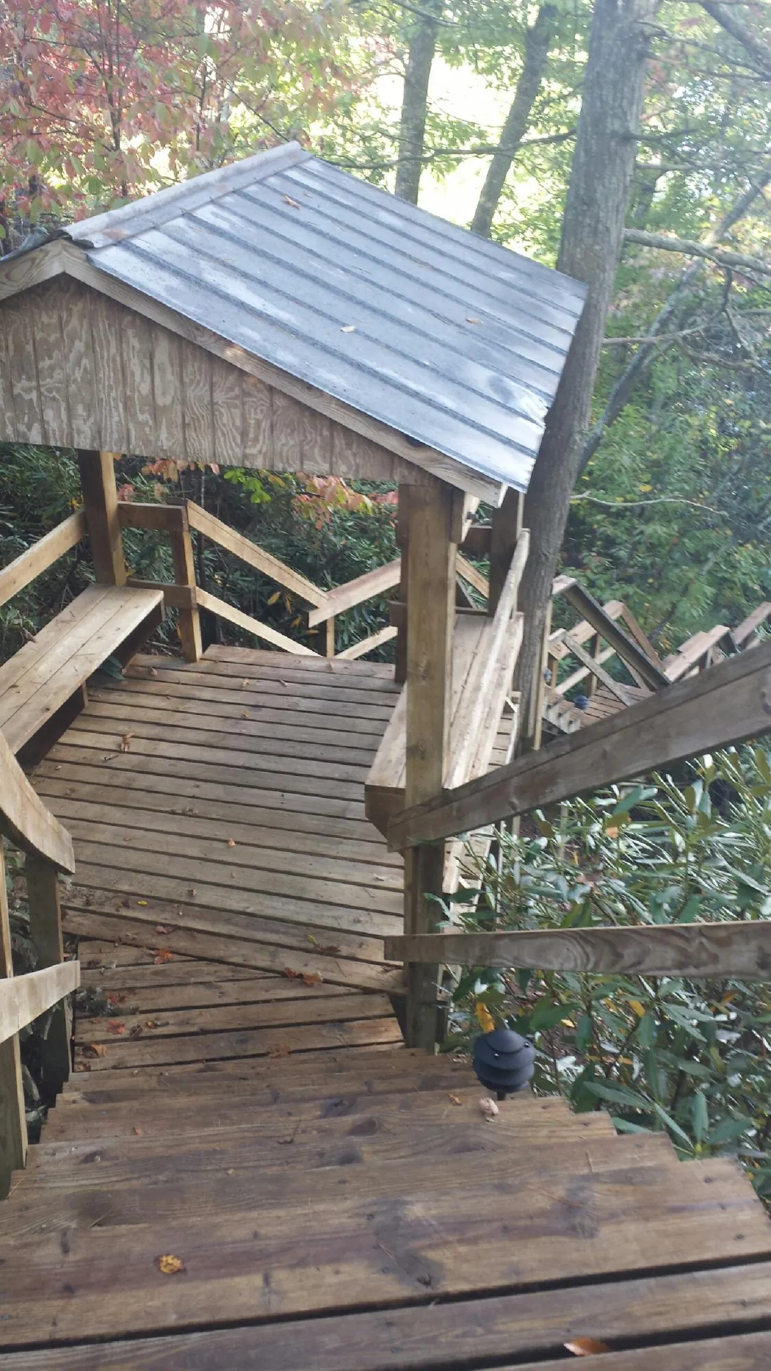 Metal roofed shelter over wooden steps on a wooded walkway — Skylight Repair & Installation work by our crew in Bayville