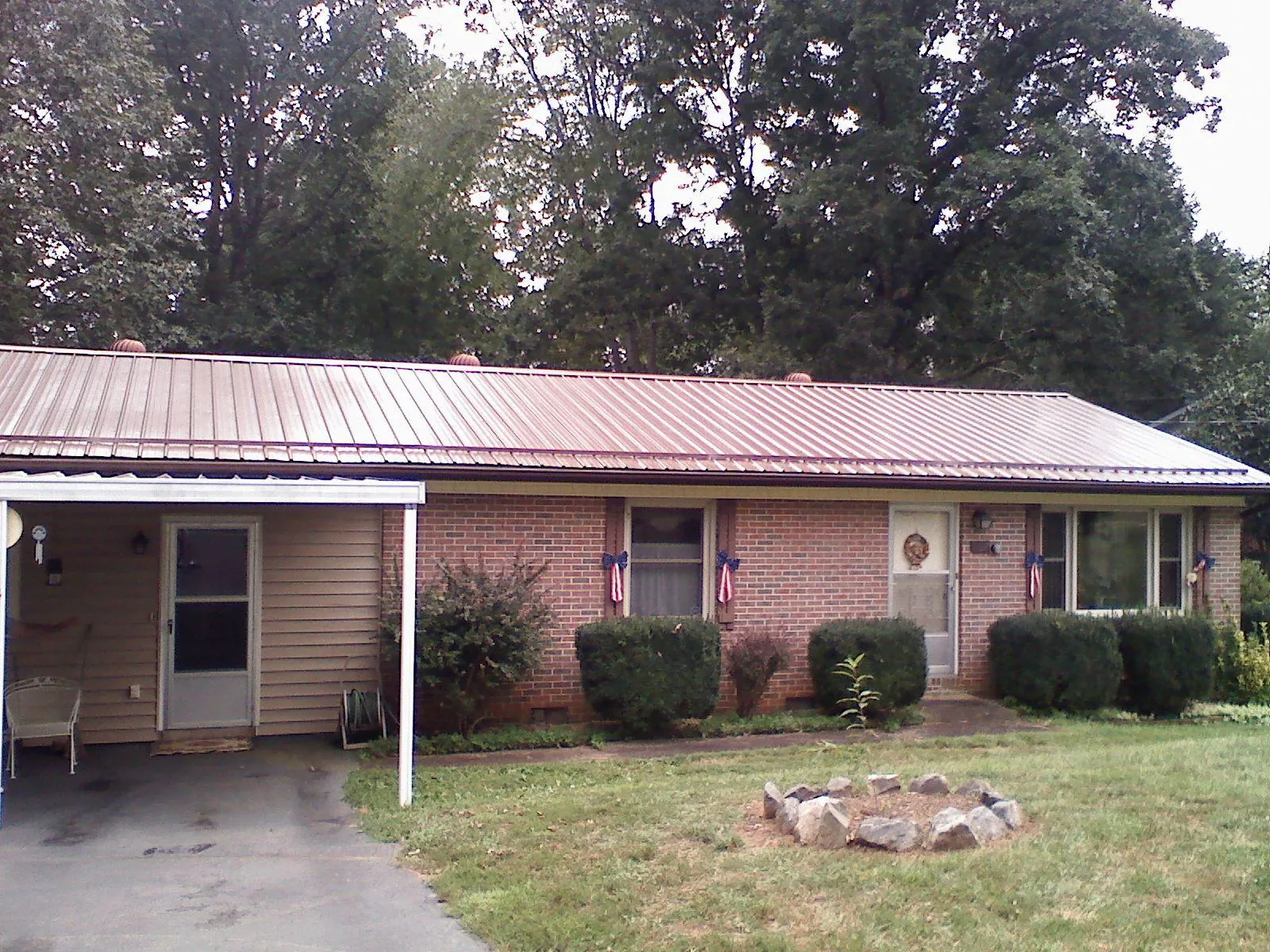 Bronze metal roof and carport on a brick ranch home — Roof Repair work by our crew in Bayville